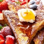 A beautiful stack of golden-brown keto French toast topped with fresh berries
