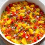 Vibrant Mango Habanero Salsa in a wooden bowl, showcasing fresh diced mango, red bell pepper, red onion, and cilantro – a delicious homemade salsa recipe